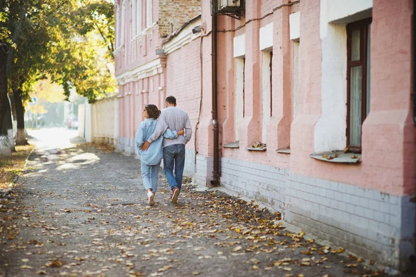 Baksidan på ungt par vandrar i gatan under hösten — Stockfoto