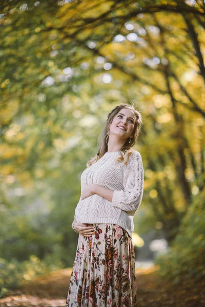 Sonbahar parkında gülümseyen hamile kadın — Stok fotoğraf