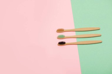 Pembe ve turkuaz arka plan üzerinde bambu diş fırçaları seti. Üstte görüntü.