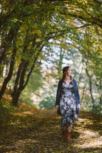 Leende gravid kvinna går i höst skogen. — Stockfoto