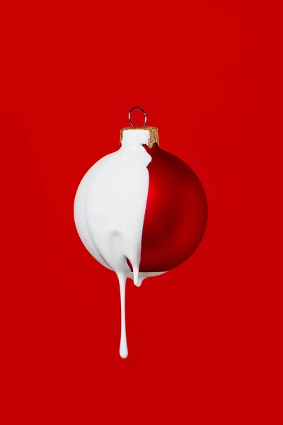 Bola roja de Navidad con pintura blanca drippinng sobre fondo rojo . — Foto de Stock