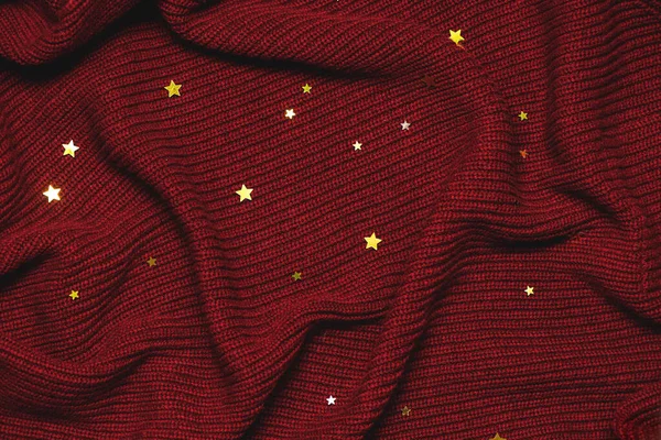 クリスマスの背景とともに黄金の星オン赤居心地の良いセーター. — ストック写真