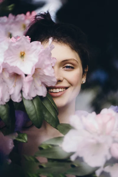 Jonge glimlachende vrouw met bloemen. — Stockfoto