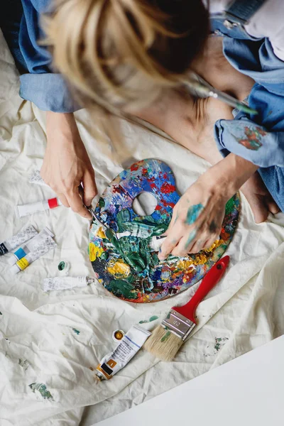 Artista femminile mescolando diverse vernici sulla tavolozza. — Foto Stock