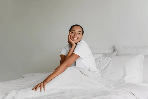 Hermosa mujer afroamericana sentada en la cama. —  Fotos de Stock