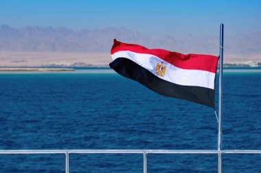 Teknede dalgalanan Mısır bayrağı, arka planda Kızıl deniz suyu ve Mısır karası