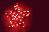 Červené vánoční hvězda rozostřený se srdcem ve tvaru bokeh jako pozadí
