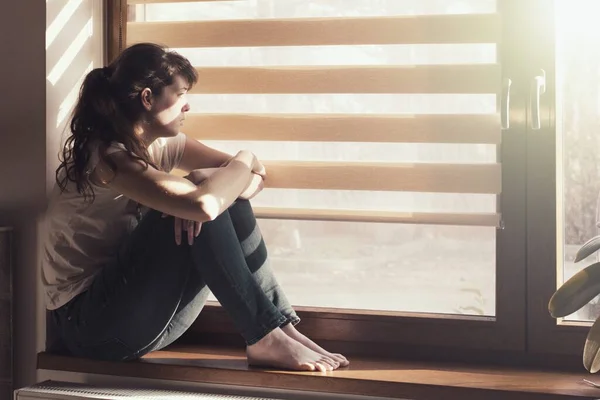 Traurige Junge Frau Die Hause Isoliert Fenster Sitzt Und Aufpasst — Stockfoto