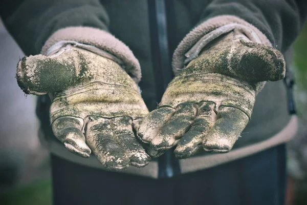 Hands with dirty working gloves