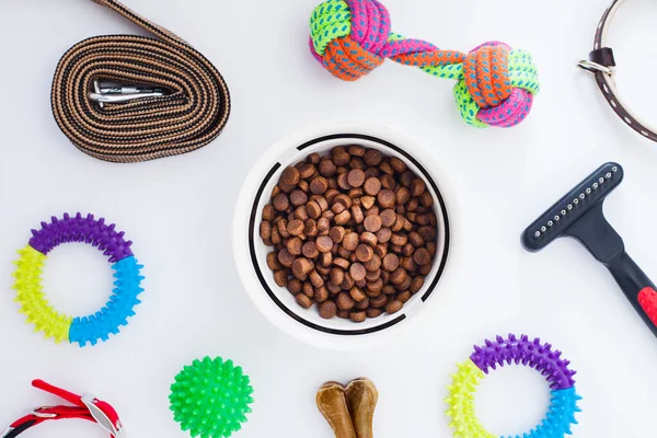 Evcil hayvan bakımı, oyun ve antrenman. Oyuncaklar, aksesuarlar ve beyaz arka planla besleniyorlar. Üst Manzara. Metin için boşluk.