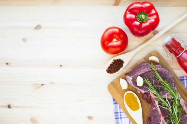 Tahtanın üzerinde çiğ et, baharatlar, biberiye ve sebzelerle. Üst Manzara. Kapatın. Yiyecek konsepti.