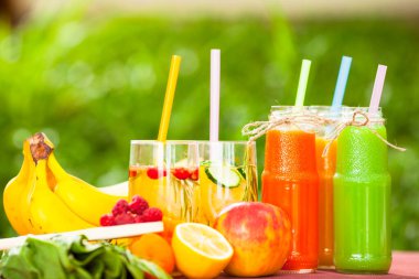 Ahşap arka planda cam şişelerdeki taze detoks sıvıları. Meyveler ve meyveler. Yaşam tarzı, vejetaryen yiyecek ve içecek, sağlık, diyet ve yaz konsepti. Üst Manzara. Kapat..