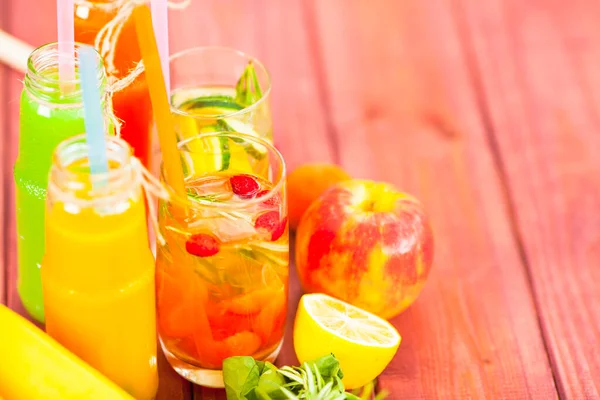 Ahşap arka planda cam şişelerdeki taze detoks sıvıları. Meyveler ve meyveler. Yaşam tarzı, vejetaryen yiyecek ve içecek, sağlık, diyet ve yaz konsepti. Üst Manzara. Kapat..