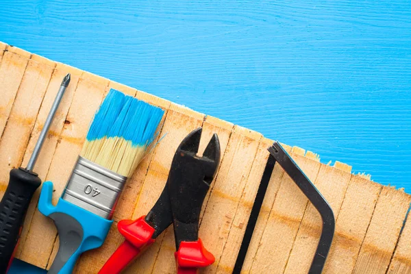 İnşaat ve onarım konsepti. Ahşap arka planda yenileme aletleri var. Üst Manzara. Mesaj atmak için yer var. Düz yatıyordu. Kapat..