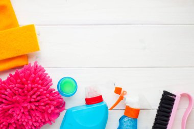 Ahşap arka planda temizlik ürünleri var. Plastik şişeler, deterjan ve fırçalar. Hizmet kavramı. Üst Manzara. Kapat..
