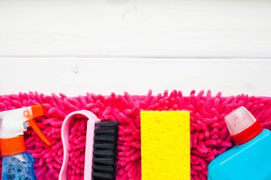 Ahşap arka planda temizlik ürünleri var. Plastik şişeler, deterjan ve fırçalar. Hizmet kavramı. Üst Manzara. Kapat..