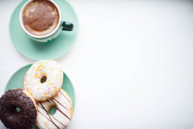 Taze demlenmiş kahve, marşmelov, donut ve tatlı beyaz arka planda. Kurdeleli ve kalpli hediyeler. Üst Manzara. Metnin için boşluk.