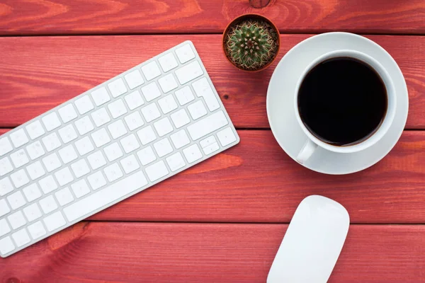 Klavye, beyaz kahve, kaktüs, abur cubur ve parlak ahşap arka planda not defteri. İş, ofis, eğitim, planlama konsepti. Üst Manzara. Kapat..