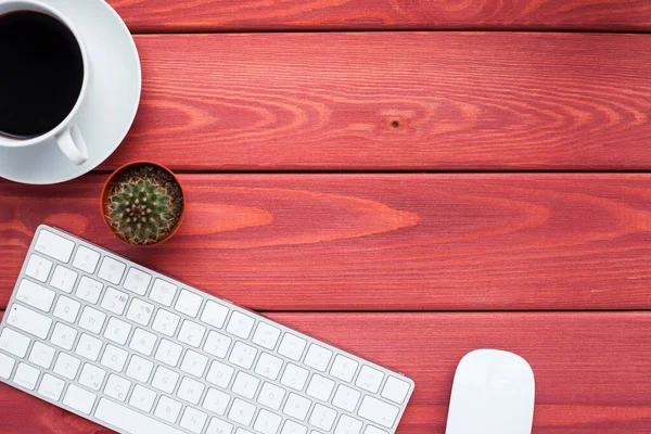 Klavye, beyaz kahve, kaktüs, abur cubur ve parlak ahşap arka planda not defteri. İş, ofis, eğitim, planlama konsepti. Üst Manzara. Kapat..