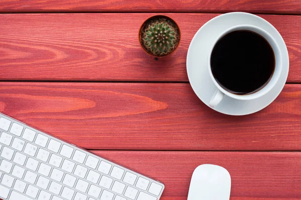 Klavye, beyaz kahve, kaktüs, abur cubur ve parlak ahşap arka planda not defteri. İş, ofis, eğitim, planlama konsepti. Üst Manzara. Kapat..
