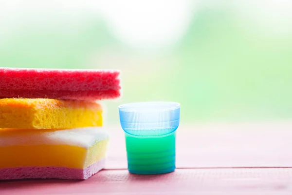 Ahşap arka planda temizlik ürünleri var. Plastik şişeler, deterjan ve fırçalar. Hizmet kavramı. Üst Manzara. Kapat..