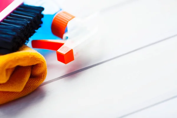Ahşap arka planda temizlik ürünleri var. Plastik şişeler, deterjan ve fırçalar. Hizmet kavramı. Üst Manzara. Kapat..