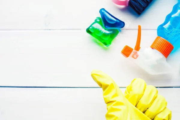 Ahşap arka planda temizlik ürünleri var. Plastik şişeler, deterjan ve fırçalar. Hizmet kavramı. Üst Manzara. Kapat..