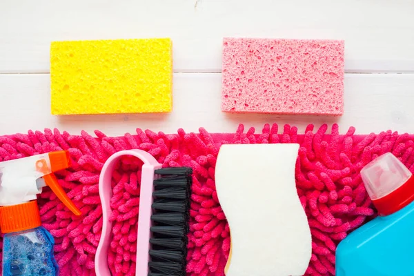 Ahşap arka planda temizlik ürünleri var. Plastik şişeler, deterjan ve fırçalar. Hizmet kavramı. Üst Manzara. Kapat..