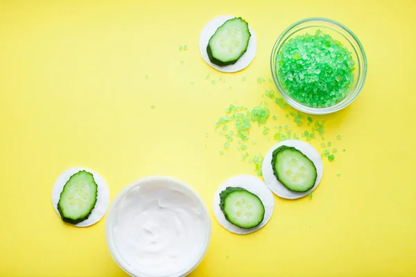 Sarı arka planda salatalıklı yeşil deniz ürünü. Deri kaplıcası. Metnin için boşluk. Üst görünüm.