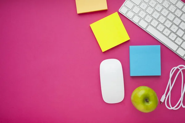 Renkli çıkartmalar, beyaz klavye, defter ve atıştırmalıklar. Ofis masası, masa ve farklı nesneler. Çalışma süreci. Eğitim, iş konsepti.