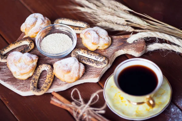 Güzel fırın ürünleri ve bir fincan kaliteli çay. Tahta arka planda kahvaltılık yemeğin düz kompozisyonu yatıyordu. Yemek, mola, yemek pişirme, yaşam tarzı konsepti. Üst Manzara. Kapat..