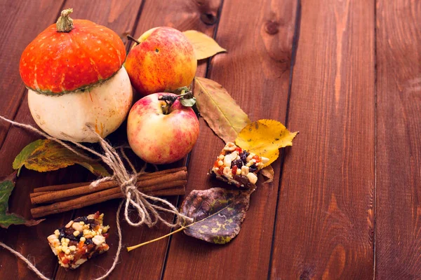  Ahşap arka planda akçaağaç yapraklı balkabağı, elma ve fındık seti. Sonbahar havası. Şükran Günü konsepti Sağlıklı yemek, diyet, yaşam tarzı ve tatil teması. Üst Manzara. Kapat..