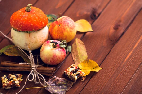  Ahşap arka planda akçaağaç yapraklı balkabağı, elma ve fındık seti. Sonbahar havası. Şükran Günü konsepti Sağlıklı yemek, diyet, yaşam tarzı ve tatil teması. Üst Manzara. Kapat..