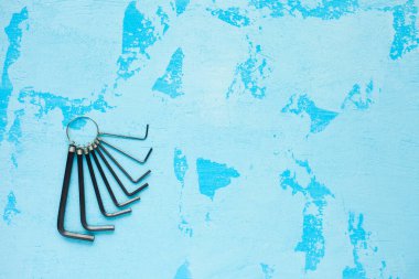 Mavi taş arka planda inşaat malzemeleri. Çekiç, vida, testere, sarı bant ve diğer küçük tamir aletleri. Üst Manzara. Kapat.. 