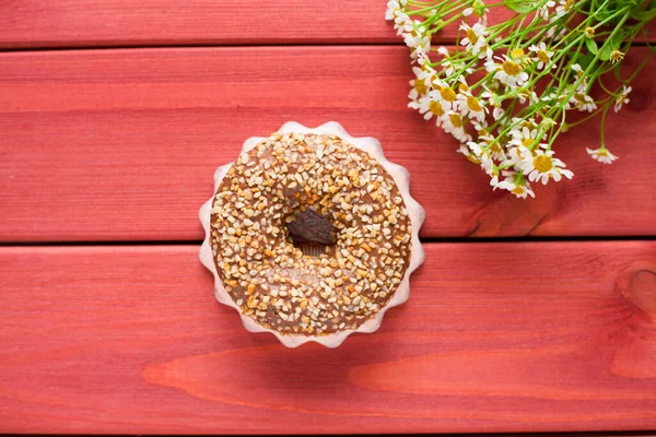 Kahvaltı ahşap masada. Bir fincan çay, çörek ve çiçek. Kapatın. Üst görünüm.