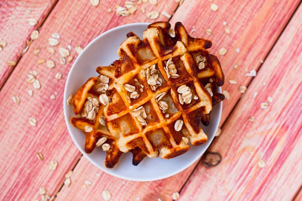 Tahta arka planda kahvaltıda elmalı ve fındıklı taze ev yapımı waffle. Üst Manzara. Kapat..