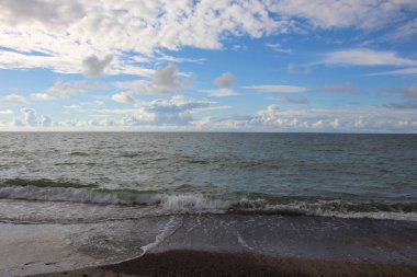 Bir yaz günü kumlu sahillere akın eden dalgalar. Baltık Denizi