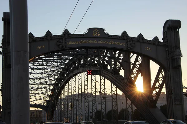 The silhouette of the bridge structures in the setting sun. The inscription on the portal \