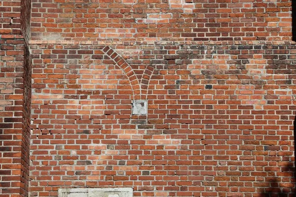 Wall fragment with vertical lines of red brick as a natural background or texture