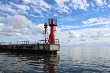 Rıhtımdaki kırmızı sabit fenere ve su fenerine yakın çekim. Baltık Denizi