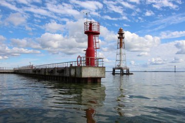 Rıhtımdaki kırmızı sabit fenere ve su fenerine yakın çekim. Baltık Denizi