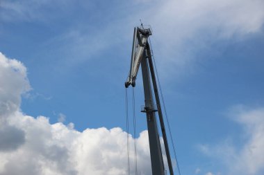 Gökyüzünün arka planında gri renkli iskele vincinin üst kısmının parçası