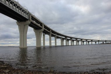 Otobandaki körfezin kıyısından, kavis üzerinde yürürken, desteklerin ve ön plandaki geçitin gökyüzüne yakın görüntüsünü al