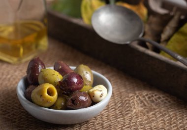 Kırsal arka planda küçük bir kasede zeytin çeşitliliği