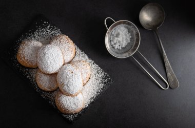 Koyu arkaplanda şekerle kaplı ev yapımı kızarmış tatlı börekler.