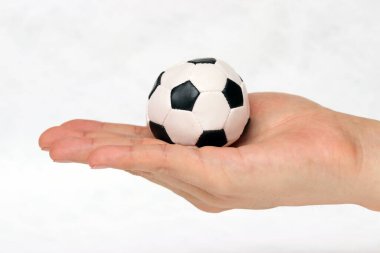 Mini futbol topu beyaz arka planda. Spor kavramı mı yoksa el altındaki oyun mu?.