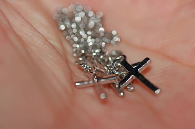 Avuç içlerindeki metal haç bileziği. inanç ve inanç kavramı.