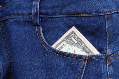Banknotun parası kot pantolonun cebinde bir Amerikan doları. Tasarruf veya finans kavramı.