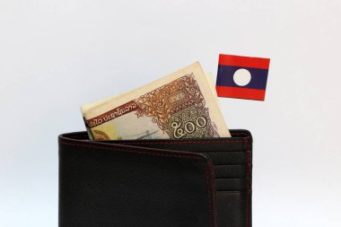 Beş yüz banknot Lao Kip ve Mini Laos bayrağı beyaz arka planlı siyah cüzdanda asılı. Finans veya para birimi kavramı.