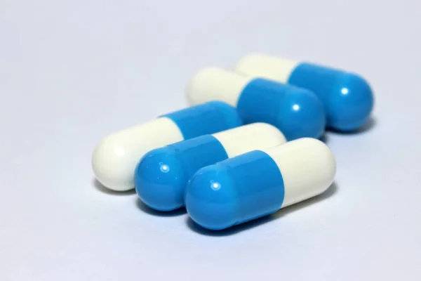 Beyaz Zeminde Beyaz Mavi Renkli Ilaç Kapsülü Yığını Küçük Bir — Stok fotoğraf